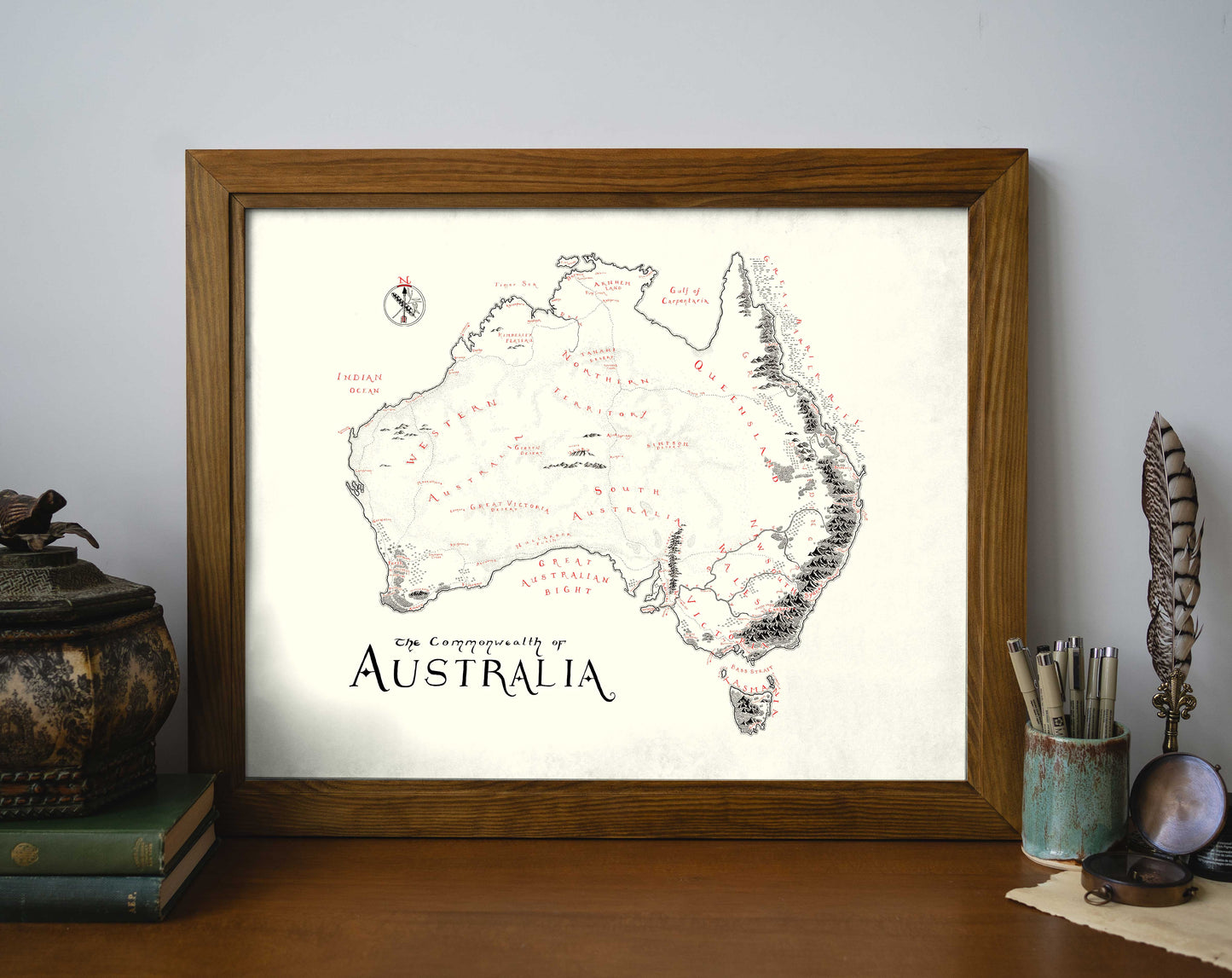 The Australia Map by Lord of Maps is a high-quality, hand-drawn print featuring "The Commonwealth of Australia" label, locations, and a decorative compass. Framed in elegant wood, it's perfect for desks and study spaces.